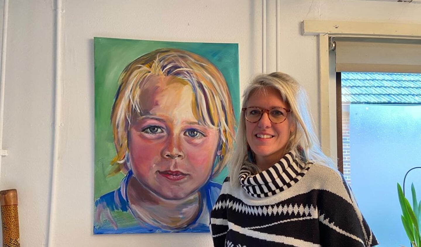 Kunstschilder Mariek Warmelink met een portret van haar zoon.