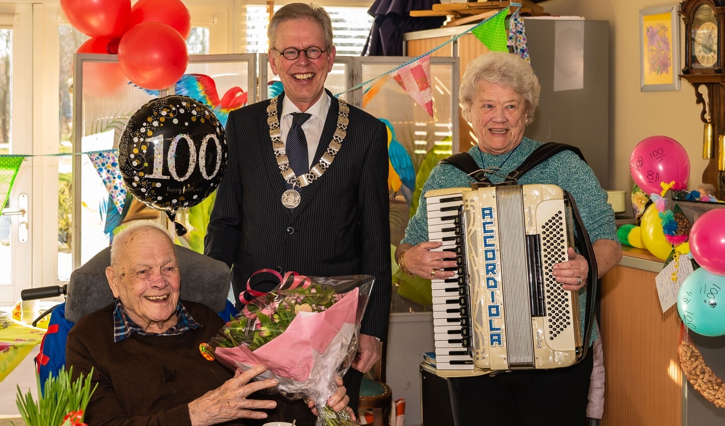 De 100-jarige Ton van Koert wordt in de bloemetjes gezet door burgemeester Don Bijl. 