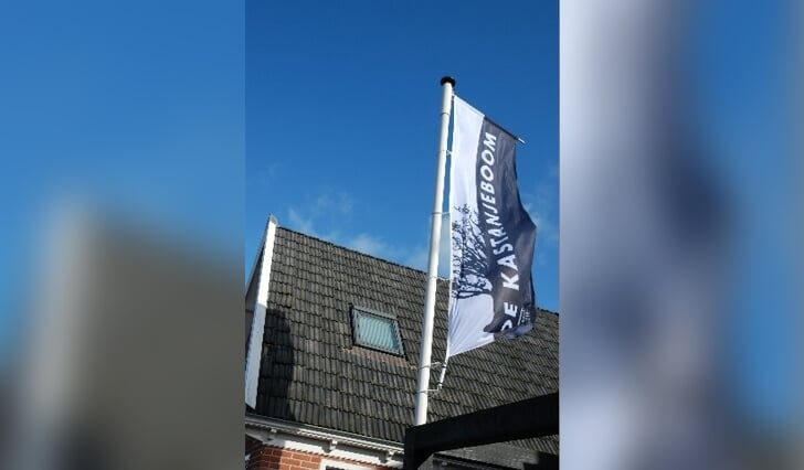 De nieuwe vlag van Dorpshuis De Kastanjeboom wappert er fier bij. 