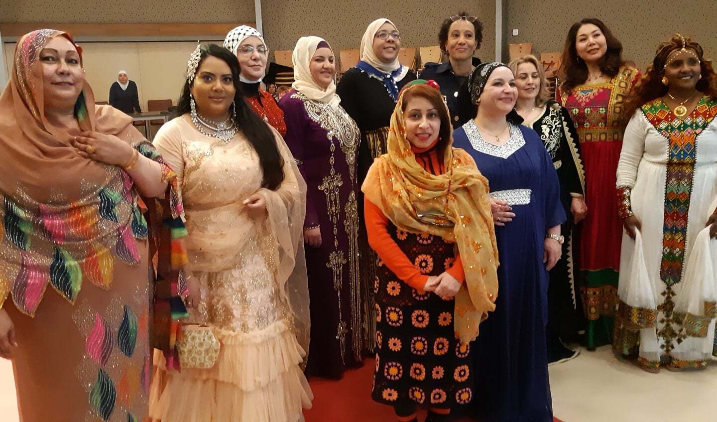 Directeur Welzijn Rijswijk Miriam Bryson te midden van de vrouwen die afgelopen zondag op de rode loper een modeshow gaven in authentieke kleding van hun land.
