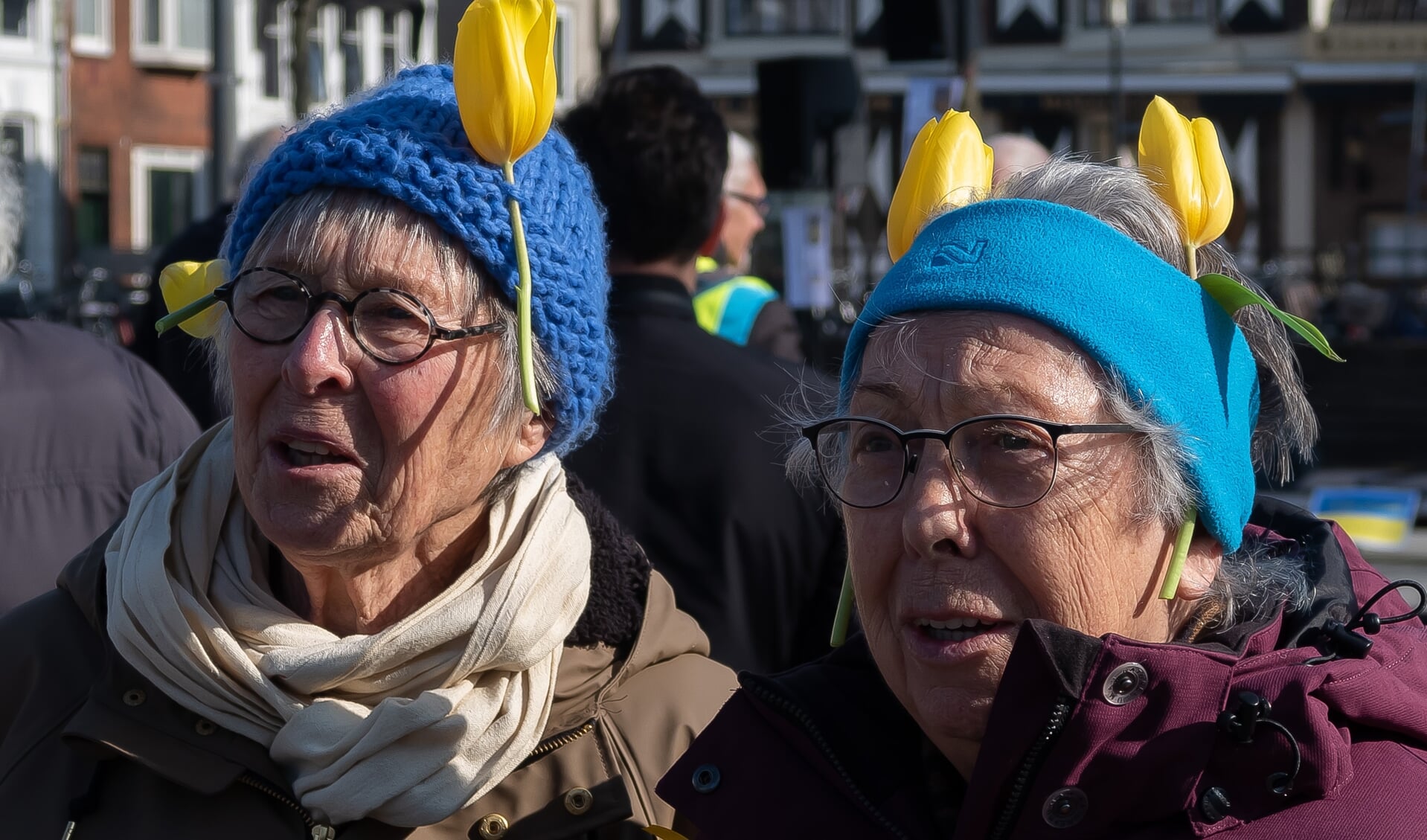 Tine Overeinder (links) en Tiny Eggers uit Zuidoostbeemster betuigden zaterdag hun medeleven door met gele tulpen in de muts naar de Koemarkt te komen.