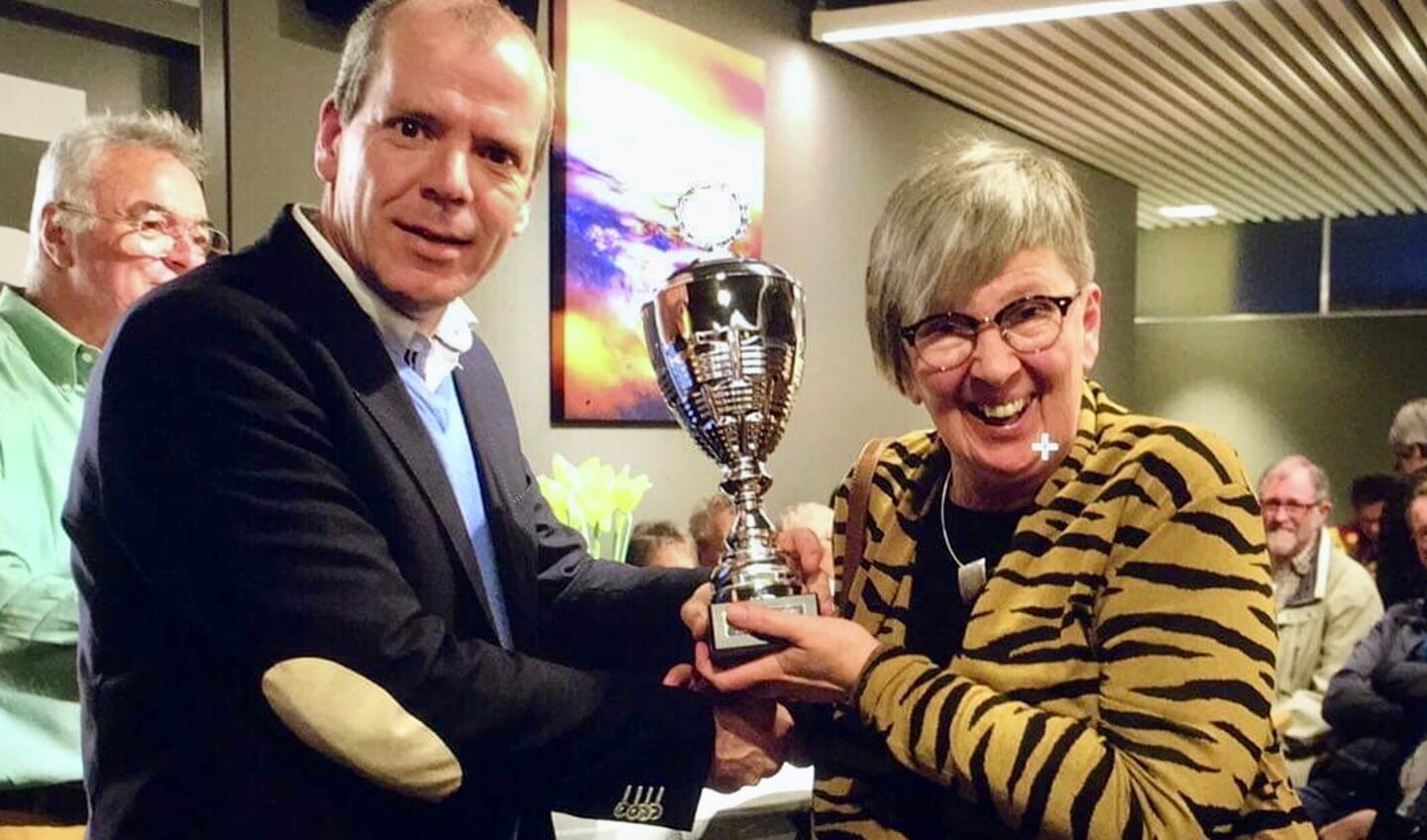 Wethouder Schotanus reikt de wisselbeker uit.