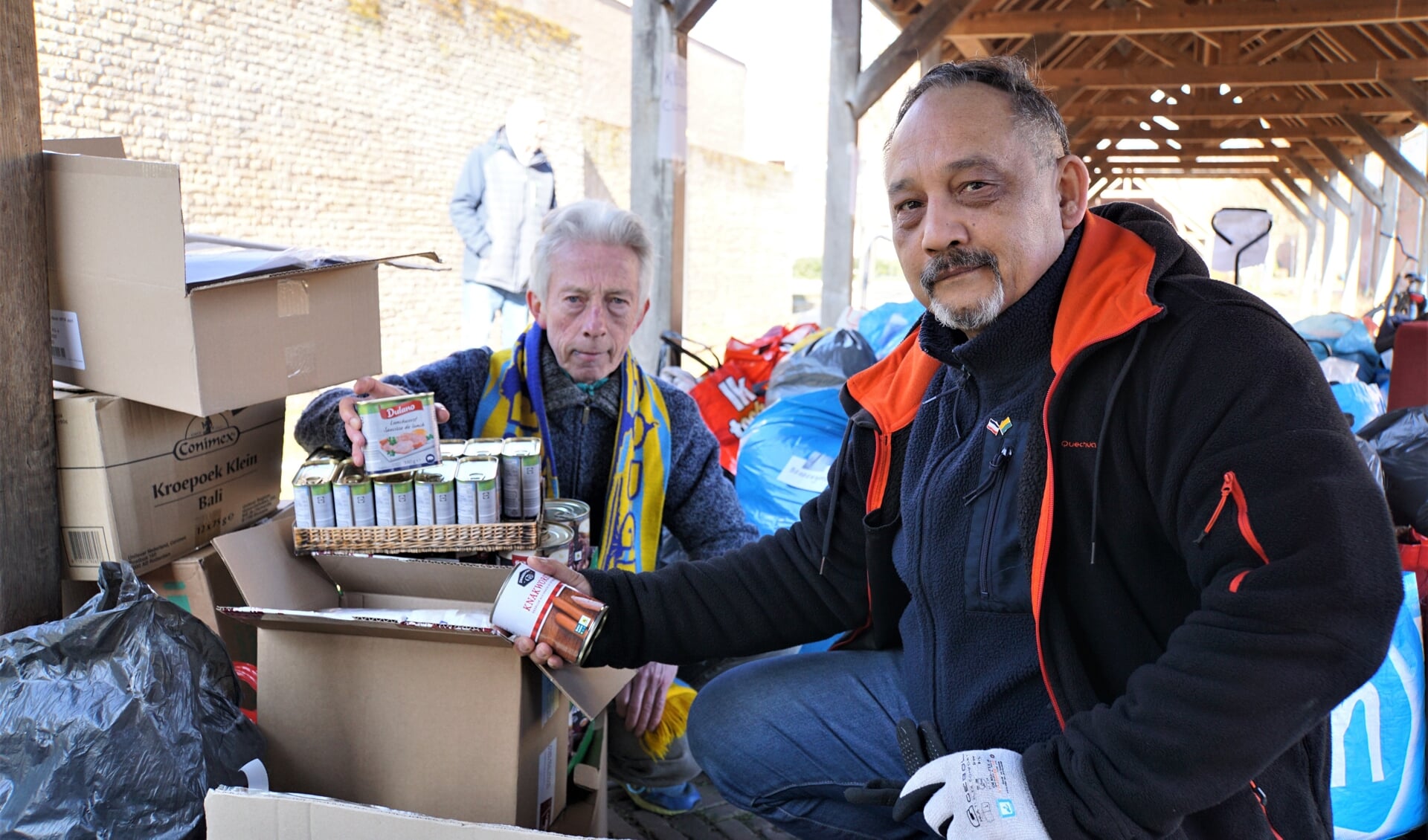 Rick Westphal (rechts) en John Kramer zitten tussen de hulpgoederen die al door veel Vlaardingers zijn aangereikt bij de stichting Spoetnik om getransporteerd te worden naar de Oekraïne.