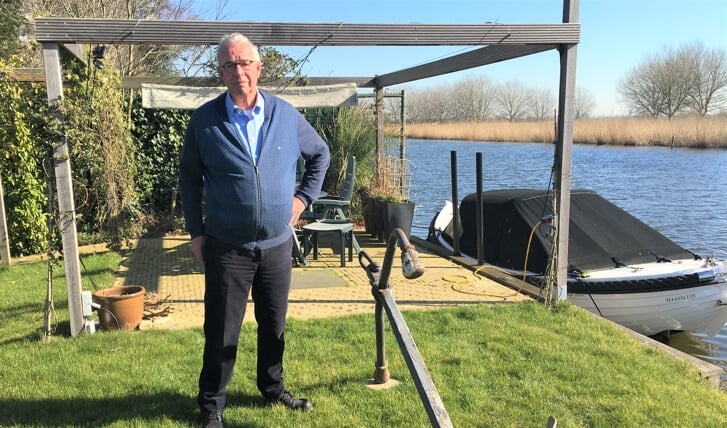 Gerrit Langelaar in zijn tuin bij het anker dat hij kreeg toen hij afscheid nam als voorzitter van Stichting Sleepboothaven Maassluis.