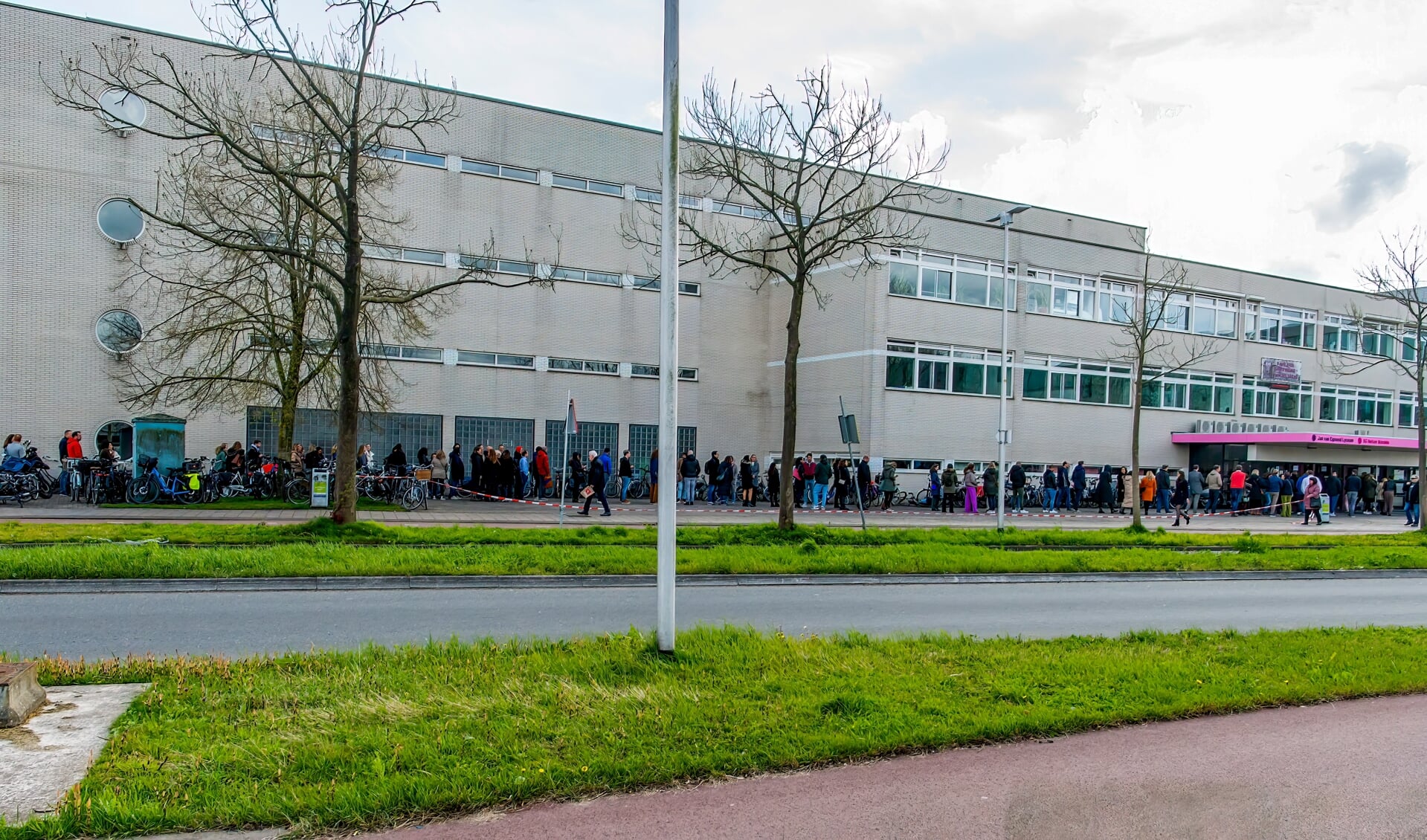 Een eindeloze rij oud-leerlingen wacht om op tijd binnen te zijn. 