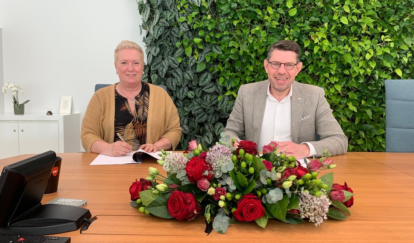 Mevrouw M. Krijnen, operationeel manager van Meld Misdaad Anoniem en burgemeester Bouke Arends ondertekenen de overeenkomst.