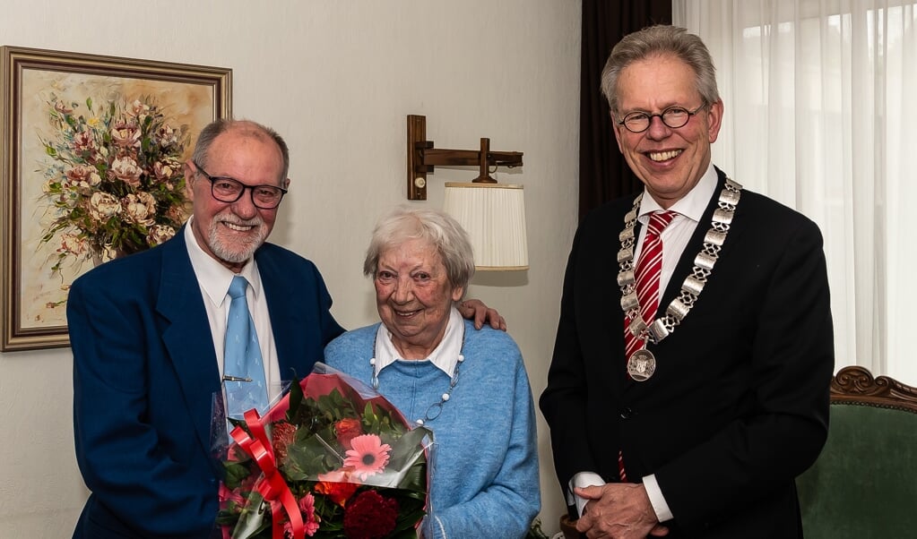 Burgemeester Don Bijl zet het jubilerende echtpaar Dijst-van Es in de bloemen.