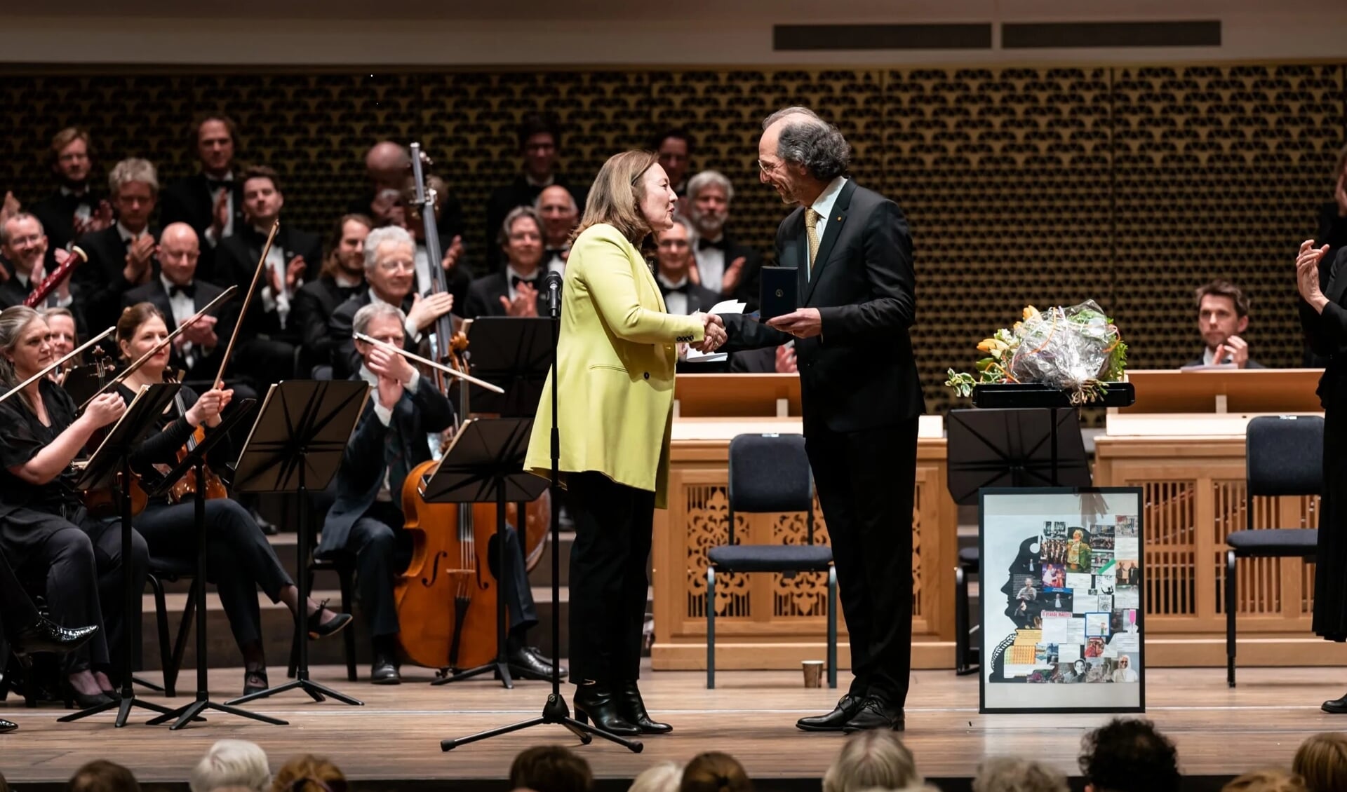 Locoburgemeester Saskia Bruines overhandigt de stadspenning aan dirigent Jos Vermunt