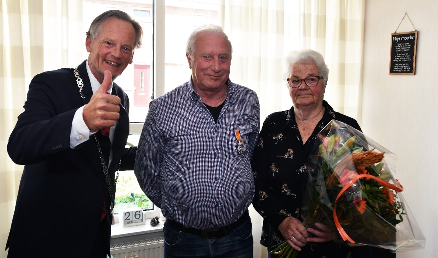 Burgemeester Streng reikte een lintje uit aan Johan Bos en zijn vrouw kreeg een bloemetje.