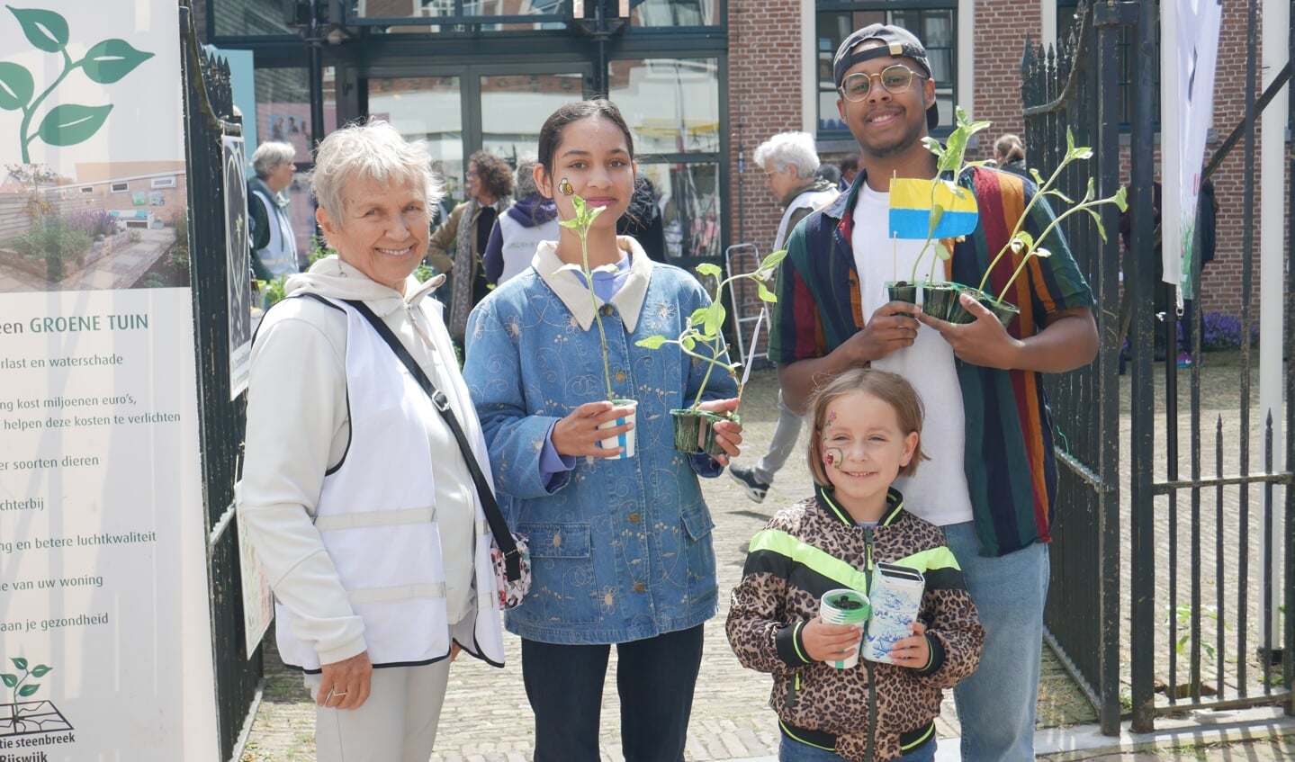 Janny Marck, voorzitter van Platform Groen en trotse oma van Cathy, Soleil en Luca voor de groenmarkt bij Museum Rijswijk. De zonnebloemen die zij uitdelen zijn door Oekraïense vluchtelingen gekweekt in Rijswijk.