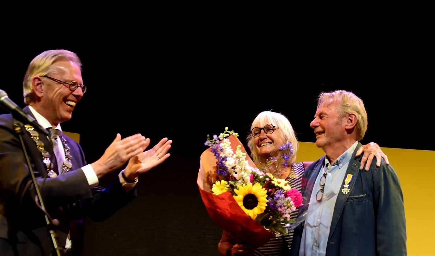 Een blij verraste Cor Stam (rechts) krijgt applaus van burgemeester Don Bijl. Naast hem zijn vrouw Ineke Waaijman. 