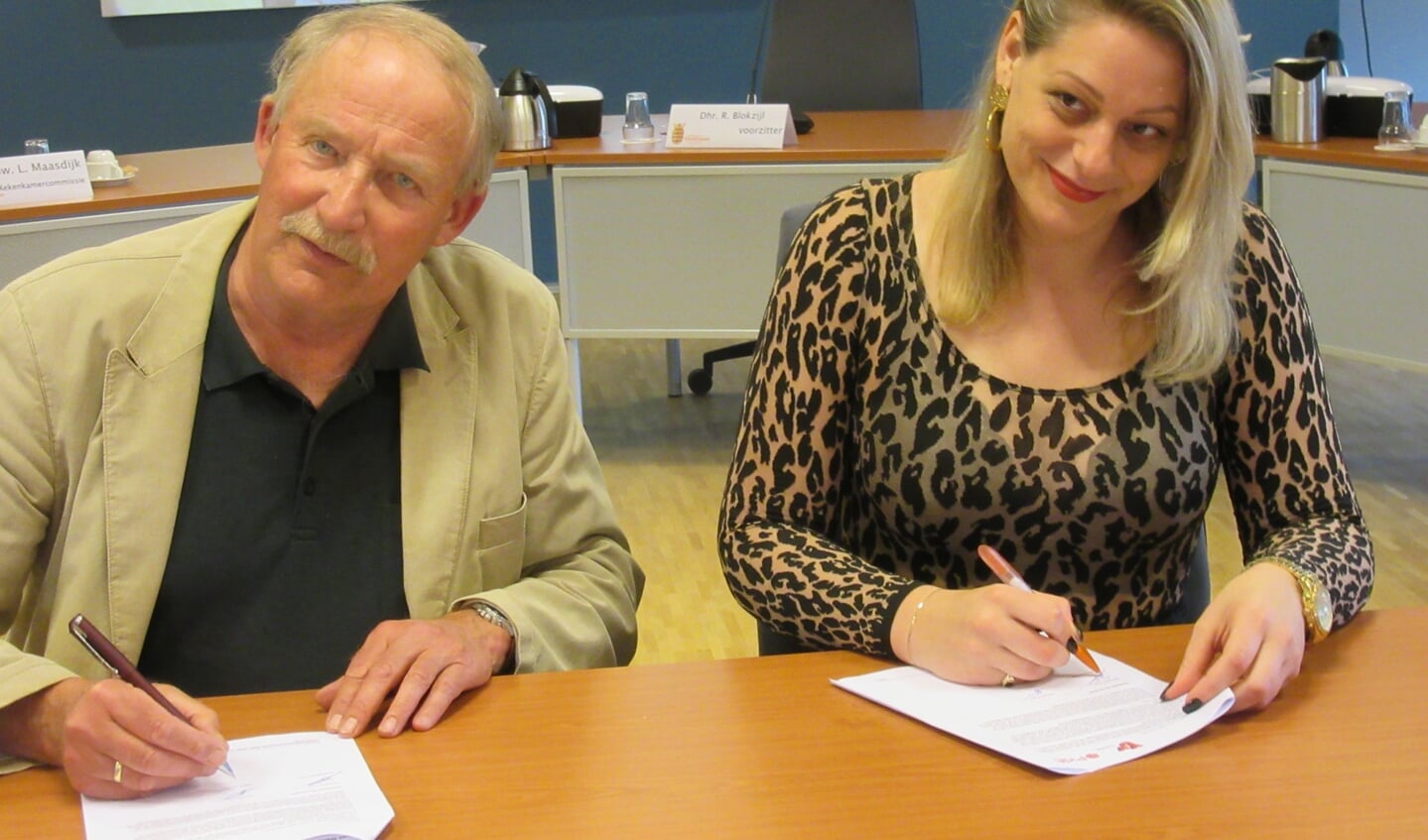 Eelco Taams en Rosemarijn Dral plaatsen hun handtekening.