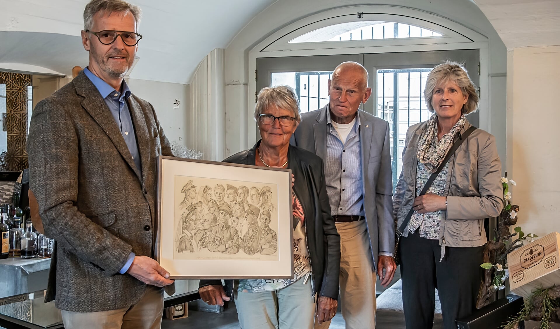 De overhandiging van het gerestaureerde werk in beeld> Van links naar rechts: Henk Bart, Mathilde Kors en de zoon en schoondochter van kampcommandant  Jan Hobo.