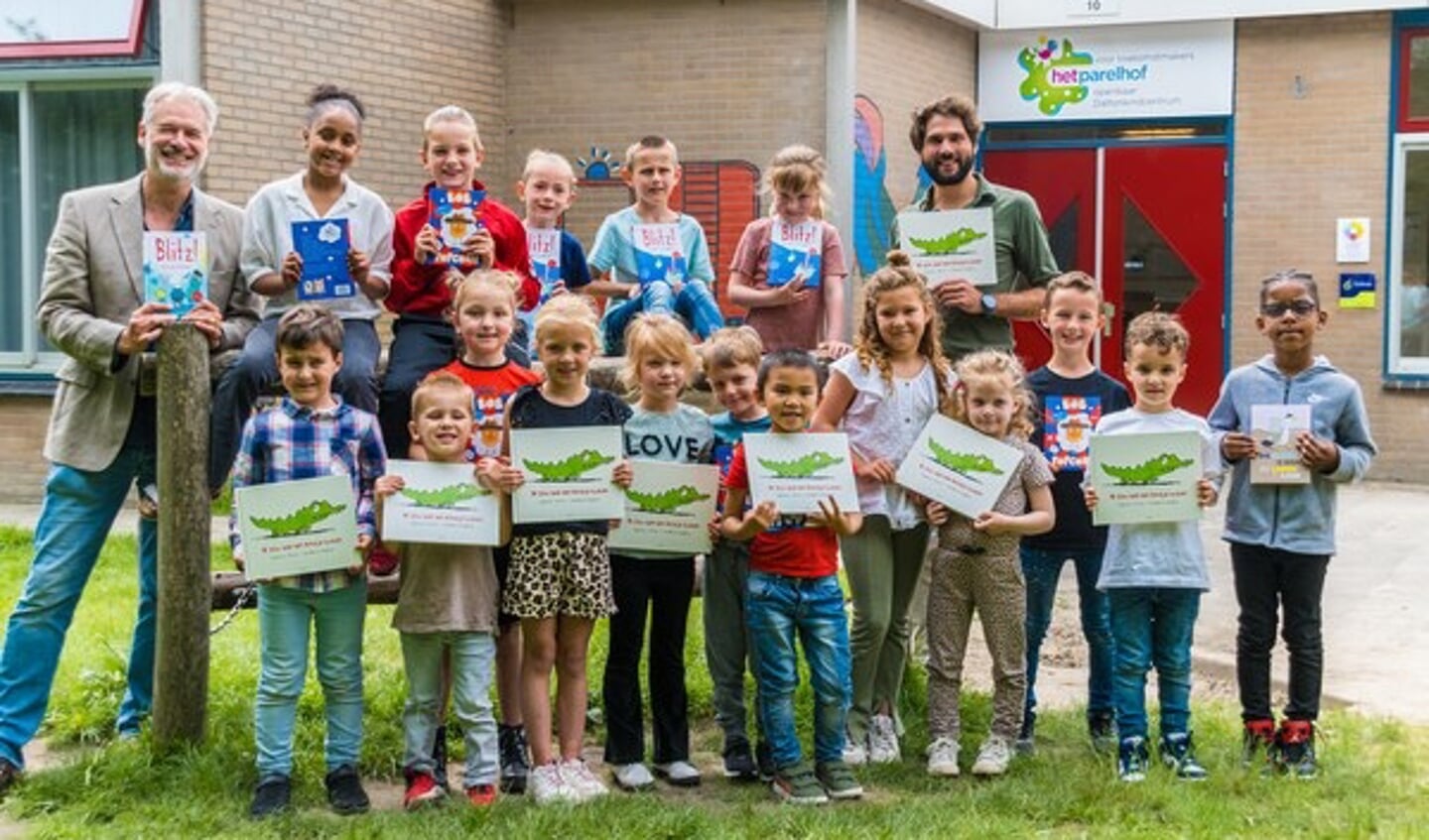 Leerlingen van basisschool Parelhof met de prentenboeken. Links Henk Schulte van Het Leesteken en rechts achter wethouder Thijs Kroese.