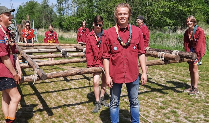 Troj de Leede, van de scoutingvereniging de Wesselgroep, voert op de nieuwe accommodatie in de Broekpolder een groepje scouts aan dragend met een vlot richting de Vlaardinger Vaart.