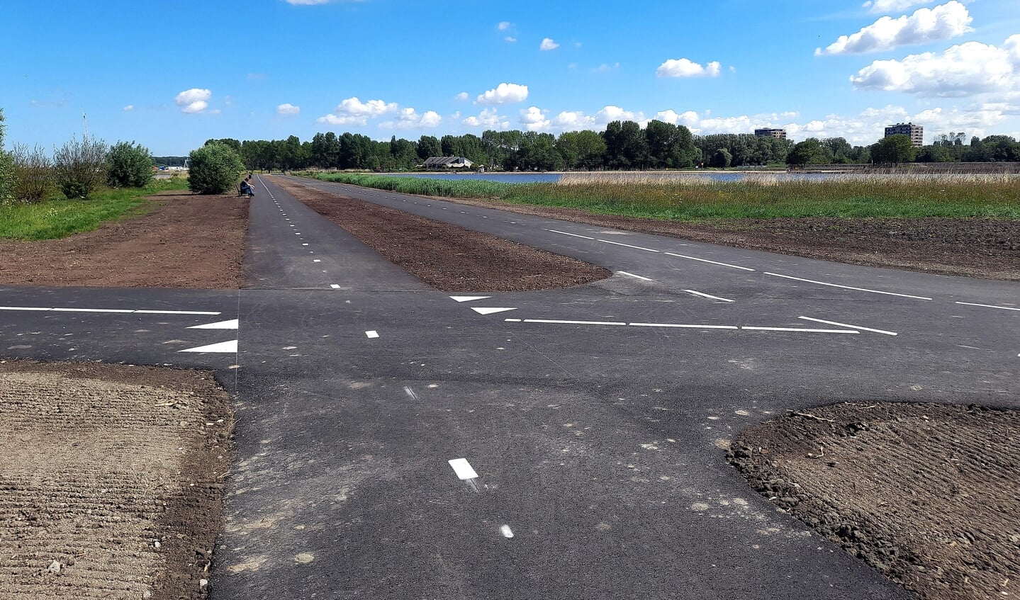 De twee nieuw aangelegde paden. Links is het fietspad met bankje.