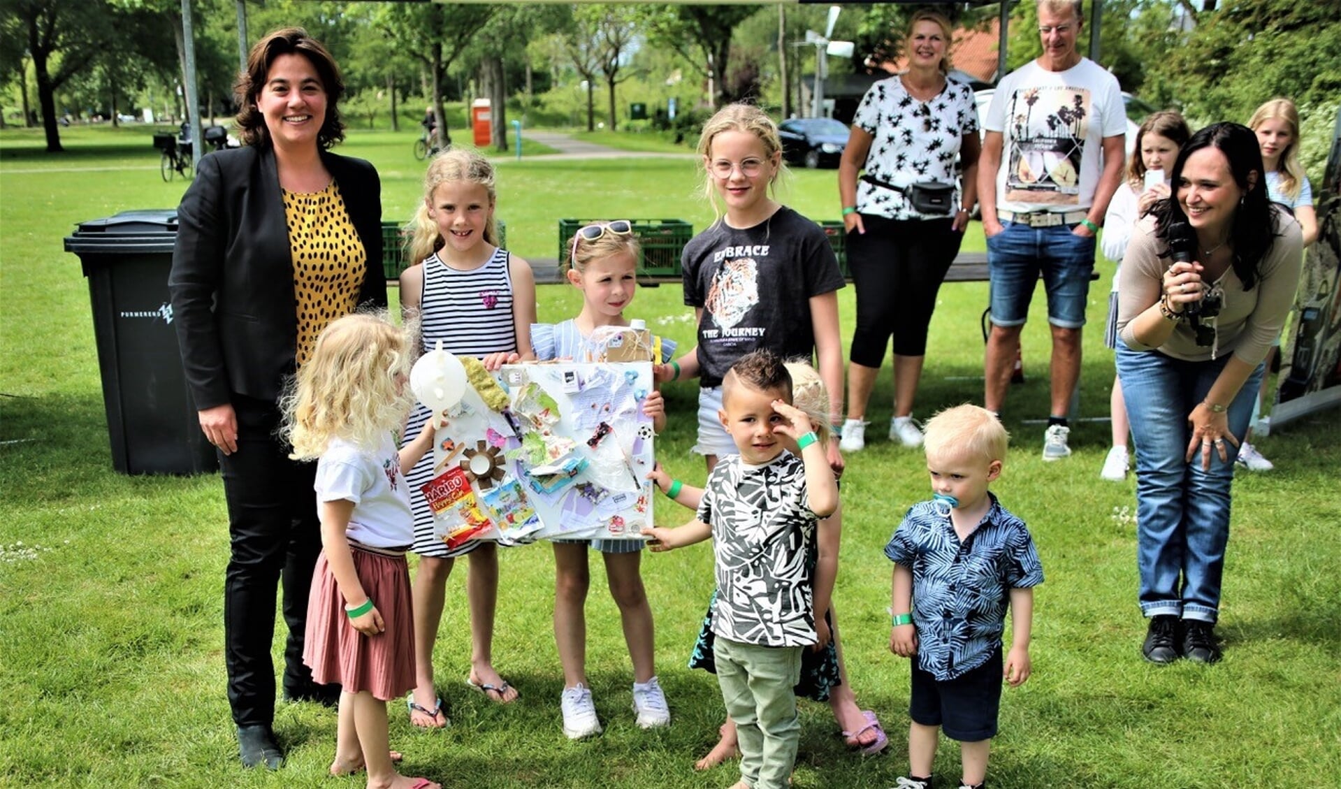 De overhandiging van het kunstwerk, gemaakt van zwerfafval door kinderen van De Wilgenhoek aan wethouder Eveline Tijmstra.