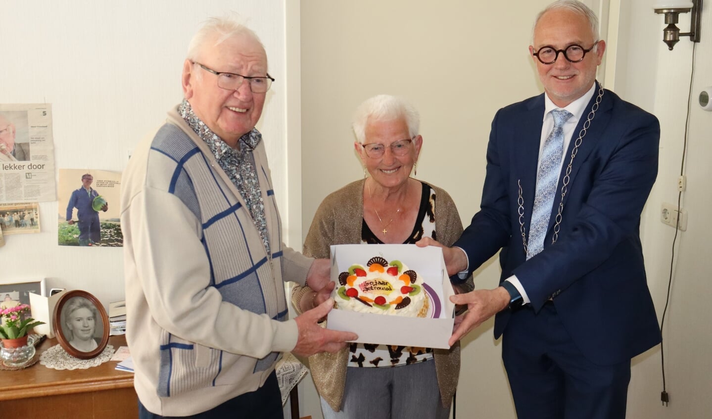 Burgemeester Van den Hengel brengt het diamanten echtpaar een lekkere taart.