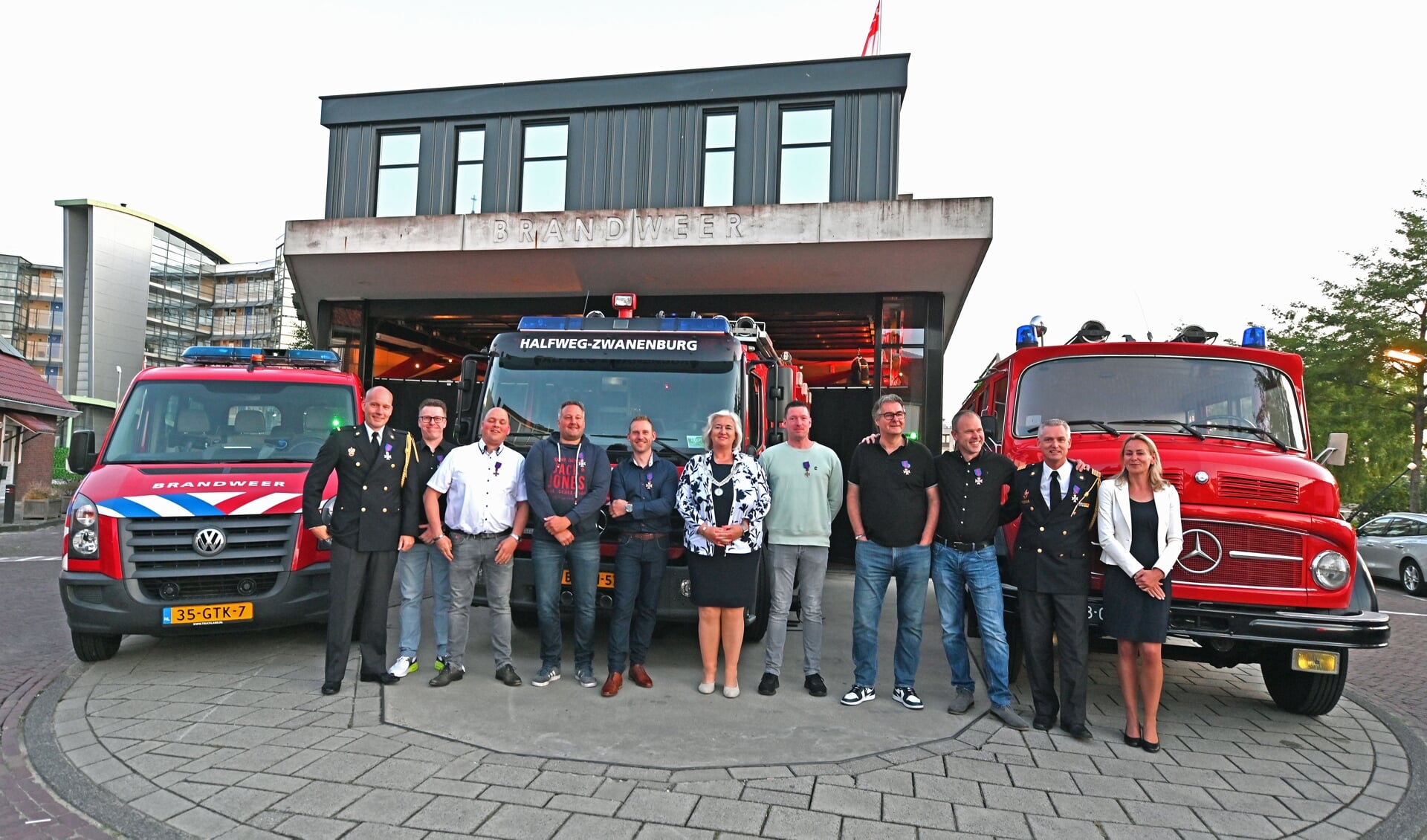 Burgemeester Marianne Schuurmans te midden van het korps van 'Brandweervereniging Halfweg-Zwanenburg'.