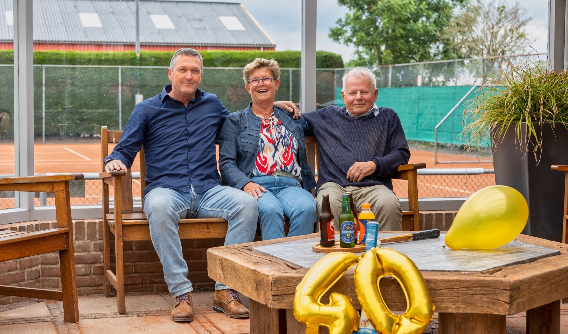 Voorzitter Wim Wijnker (l), penningmeester Jeltje Karman en oud-voorzitter Wout Beers zijn blij het jubileum van hun geliefde tennisvereniging te kunnen vieren met de leden.