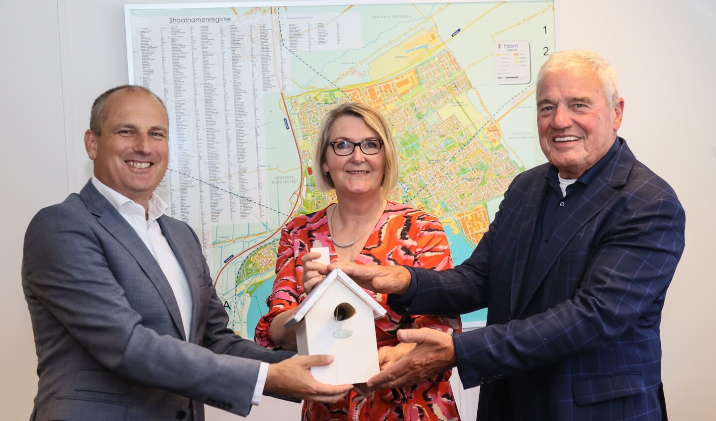 Peter Heuvelink en Jan van der Linden overhandigen een EWF-vogelhuisje aan wethouder Marjon van der Ven om de anterieure overeenkomst te vieren.
