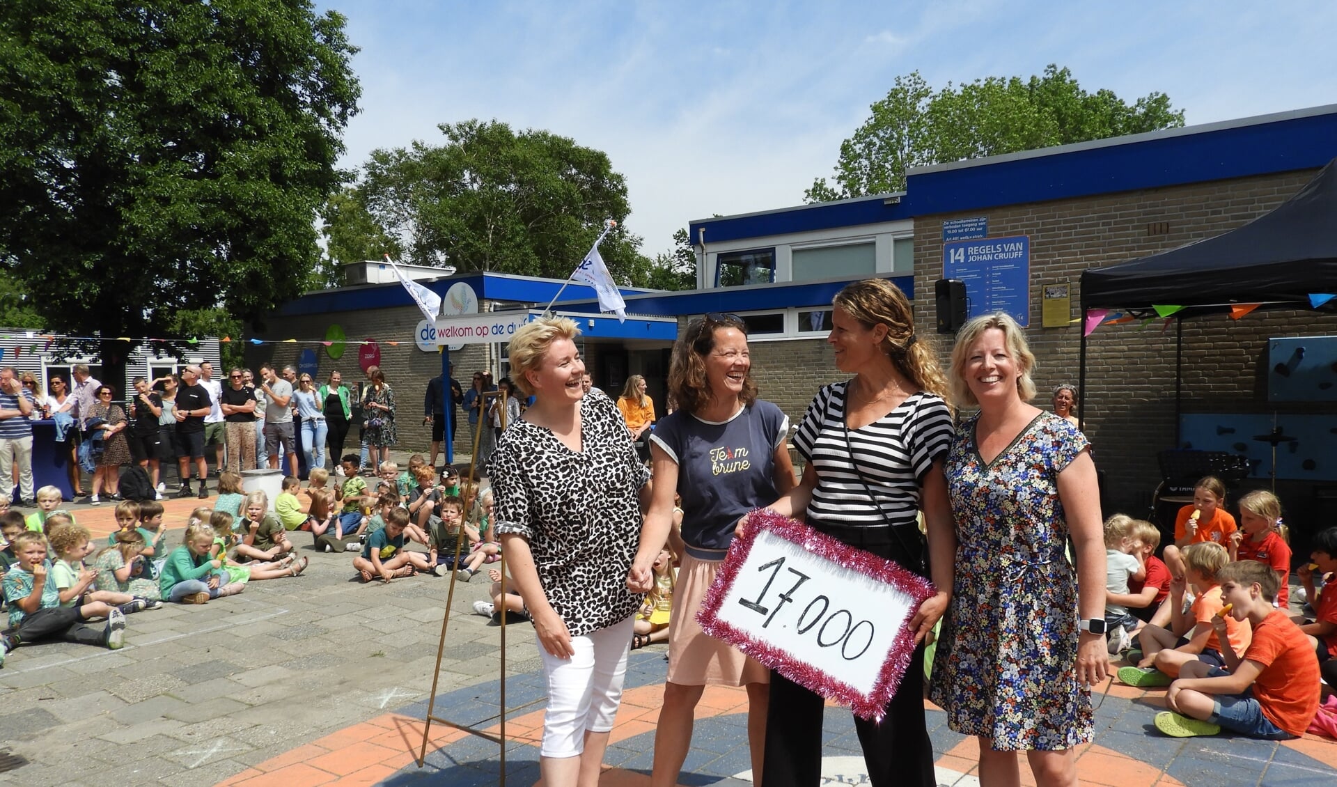 Een deel van de ouderwerkgroep van kindcentrum De Duif maakt de opbrengst van de sponsorloop bekend voor een groener en actiever schoolplein.