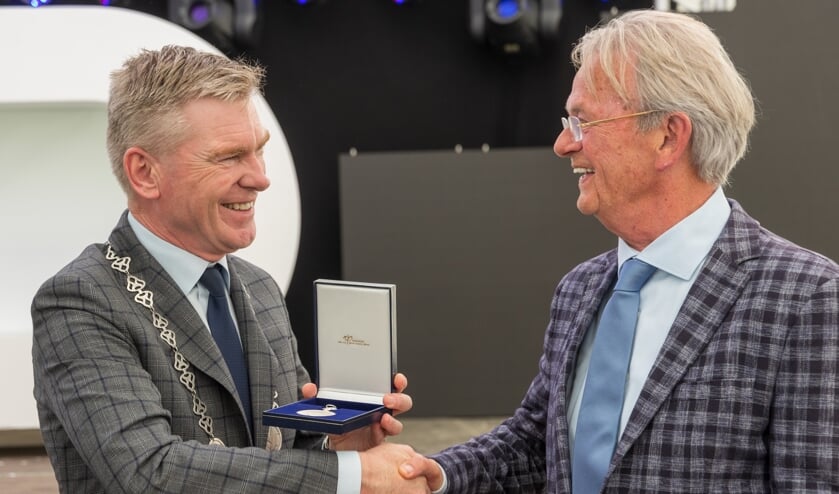 Jan van der Ben nam de Koninklijke Erepenning in ontvangst van waarnemend burgemeester Peter Rehwinkel.