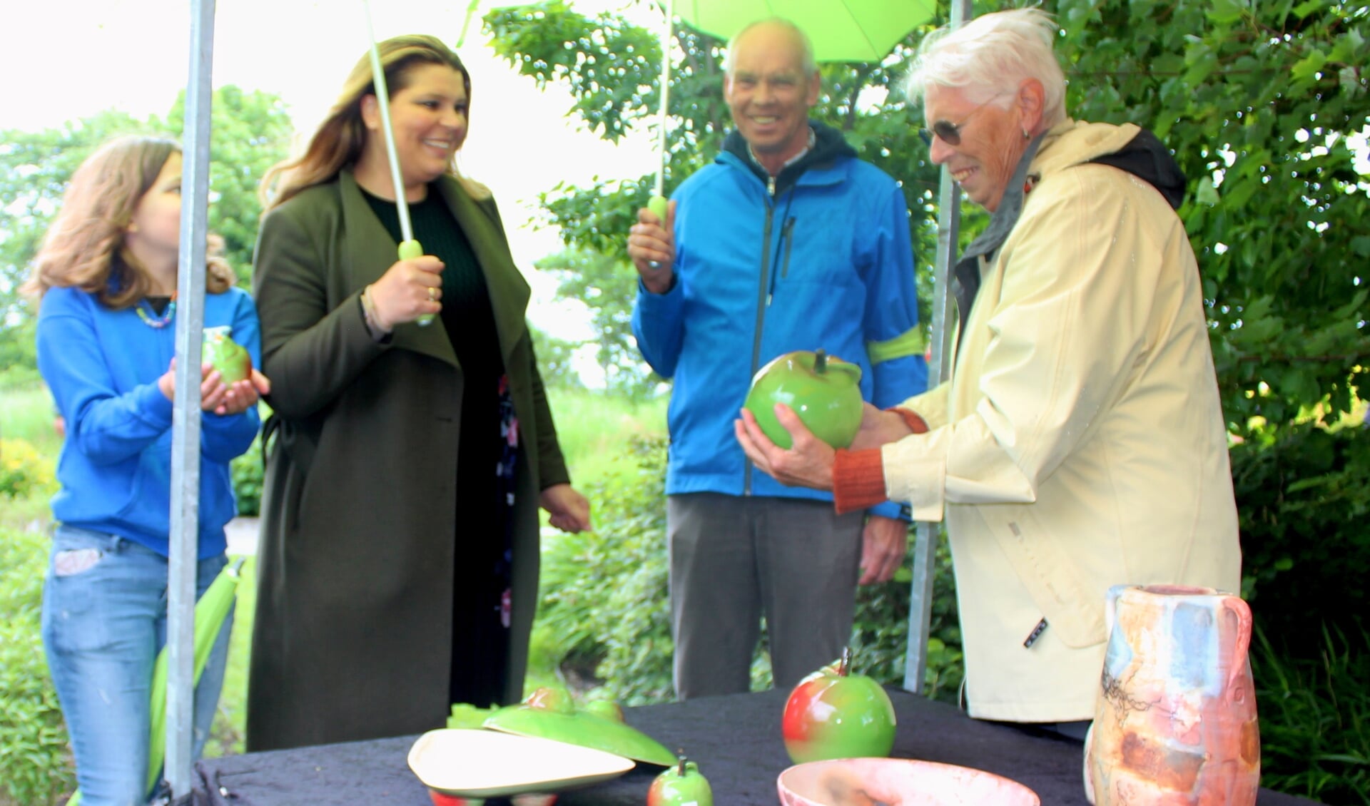 Wethouder Anouk Noordermeer, op Kunst & Groen rondgeleid door organisator Jos van Lint, bewondert de keramiek appels 'Schone van Boskoop', van kunstenares Els de Jong. 