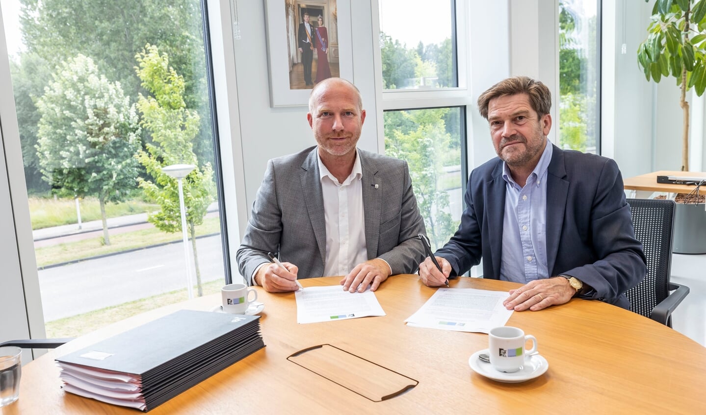 Wethouder Michiel Ferwerda en Wilfried Stribos onderteken de overeenkomst.