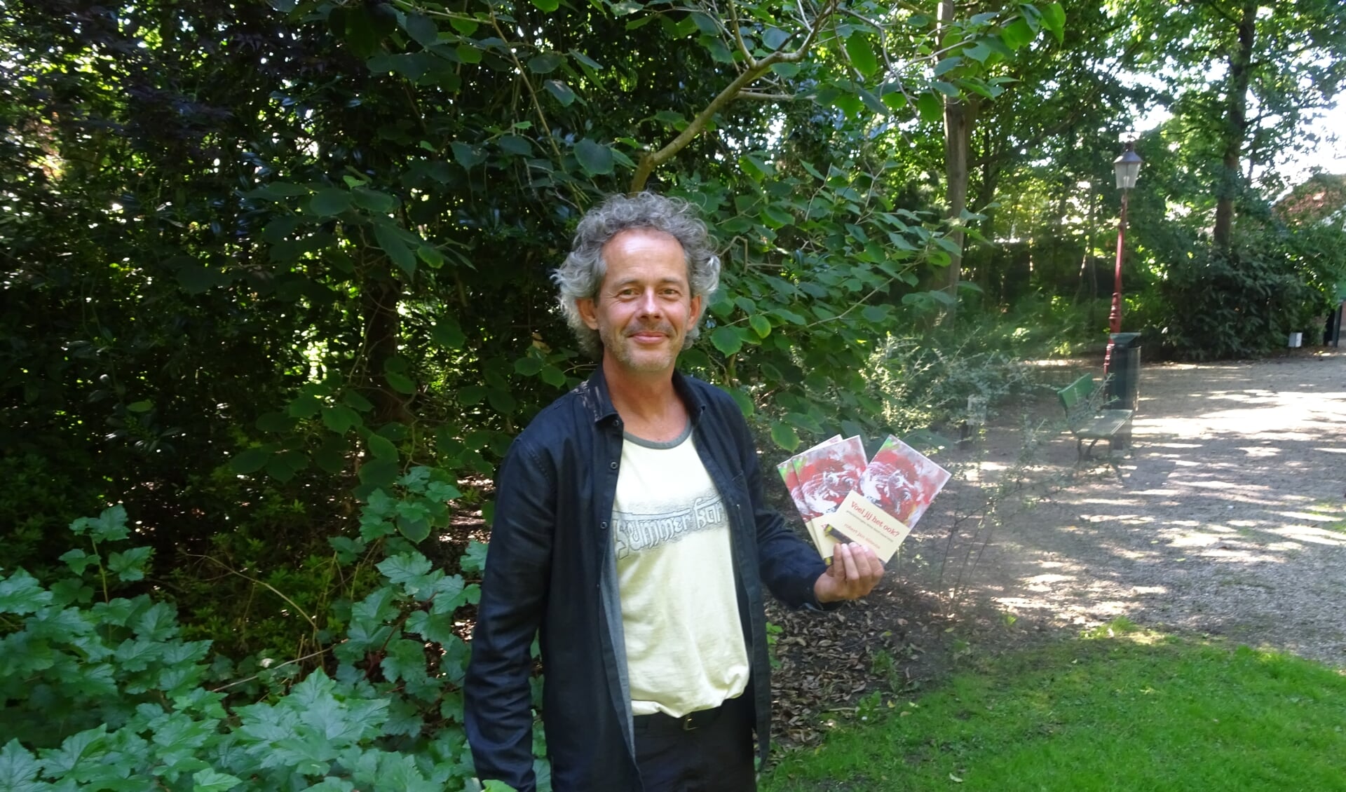 Robert Jan Simons poseert trots in het Wilhelminapark met zijn "Voel jij het ook"
