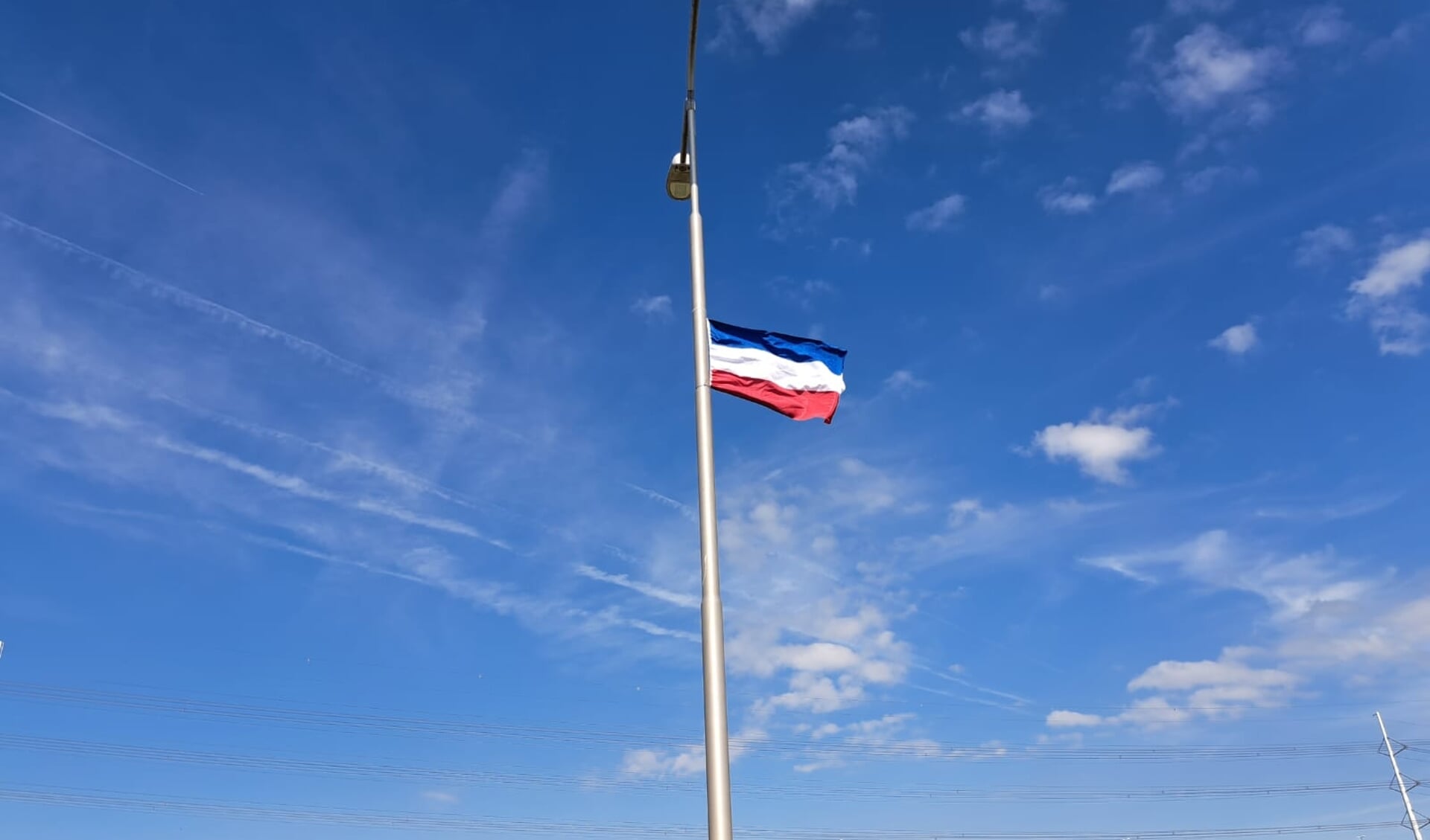 Een omgekeerde vlag aan een lantaarnpaal langs de N468 (bij Den Hoorn) op donderdagmiddag 14 juli.