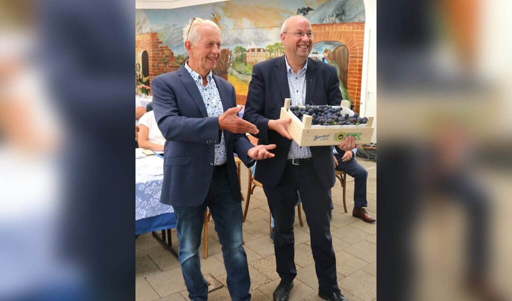 Jos van der Knaap (l.) en pastoor Jaap Steenvoorden laten een kistje met het nieuwe keurmerk zien.