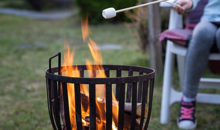 Boven de vuurkorf marshmallows aan een stokje verwarmen, het ziet er leuk uit maar geeft de rook overlast? Dan is het voor de buren een stuk minder leuk....
