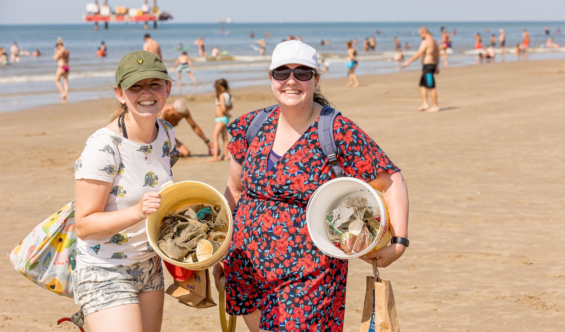 Twee vrijwilligers die het strand afvalvrij maken