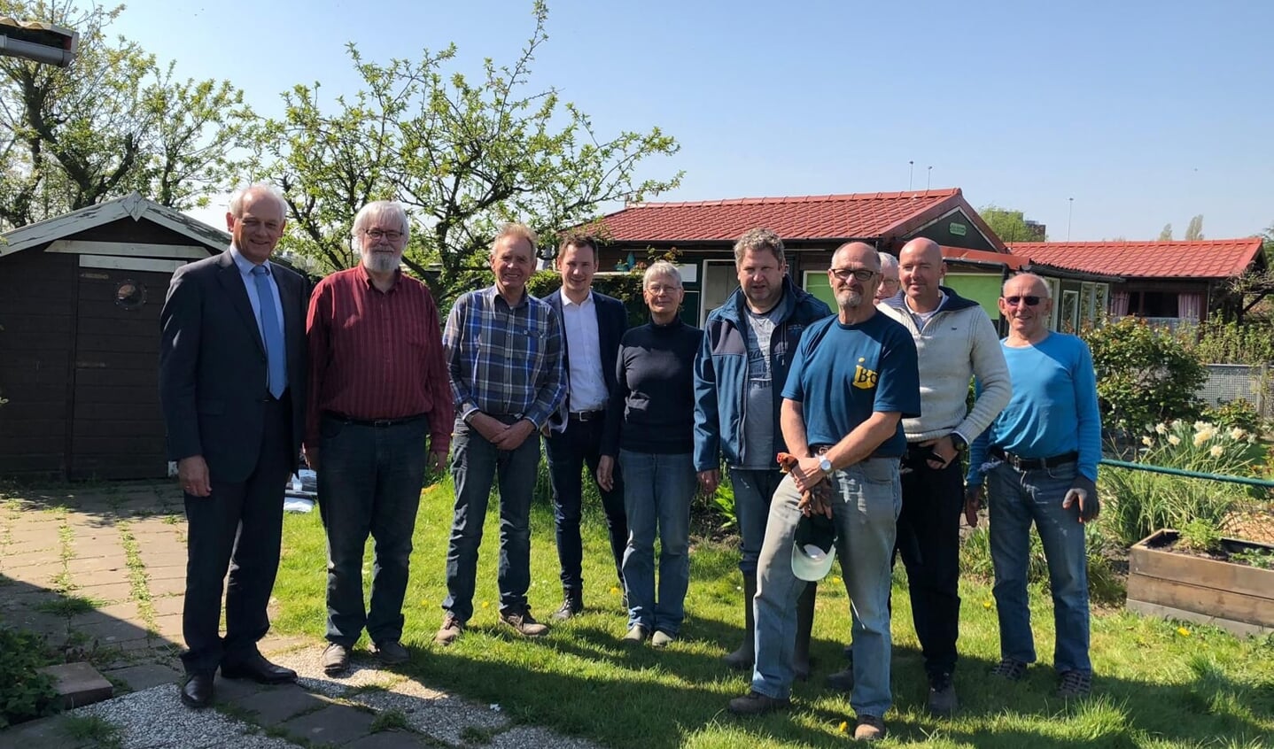 Burgemeester Cor Lamers, helemaal links, kwam in 2019 naar Vijfsluizen om Herbert Nikkels (derde van links) een lintje op te spelden. Enkele vrijwilligers van Stadstuinieren waren erbij aanwezig.