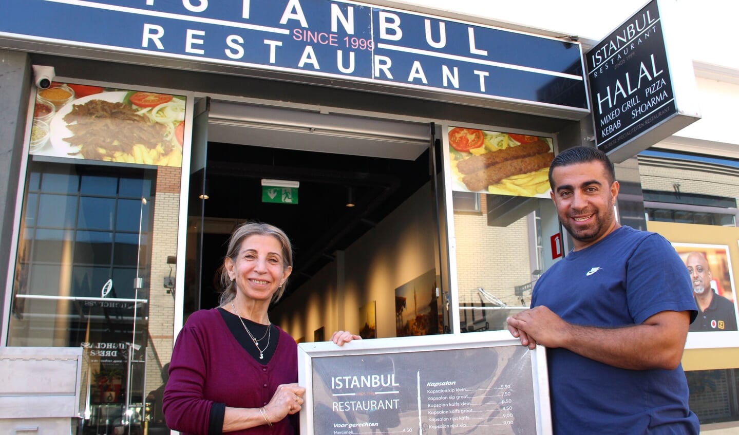 Eigenaar Jiar met zijn moeder Nas voor het nieuwe restaurant, tegenover de Hoogvliet