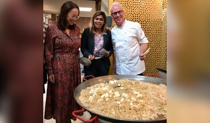 TV-kok Rudolph van Veen bereidt zijn 'Transvaal Rijst', hier met wethouder Kavita Parbhudayal (midden) en bankdirecteur Renata Brabander.