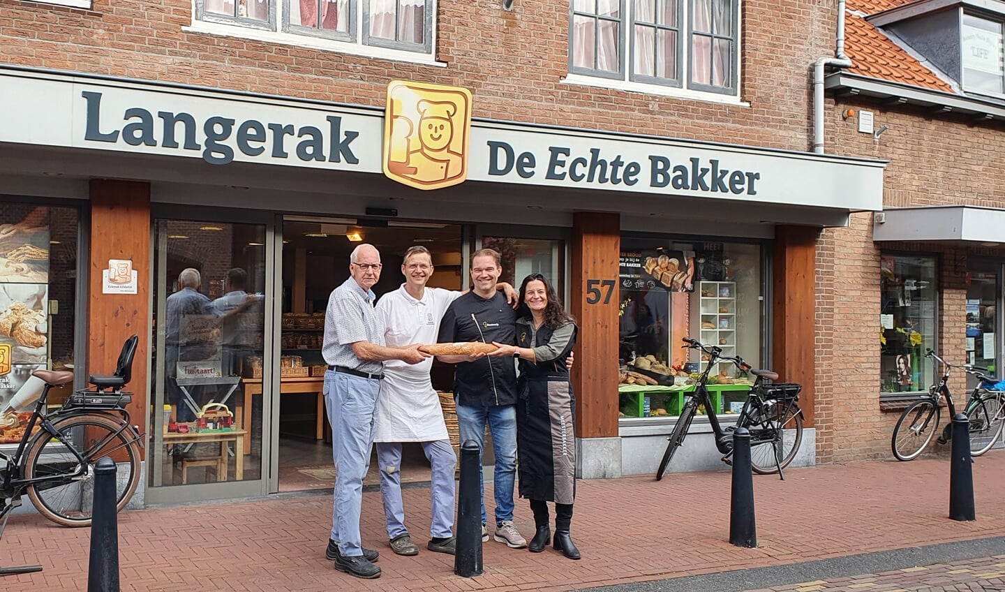 Sander Langerak draagt, samen met zijn vader Gerard, het stok(brood)je over aan Edwin en Marja.