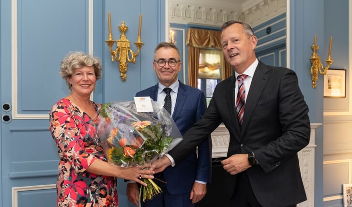 Jos Wienen, Burgemeester Haarlem is door de Commissaris van de Koning Arthur van Dijk beëdigd. Naast Wienen staat zijn vrouw die de bloemen in ontvangst neemt.