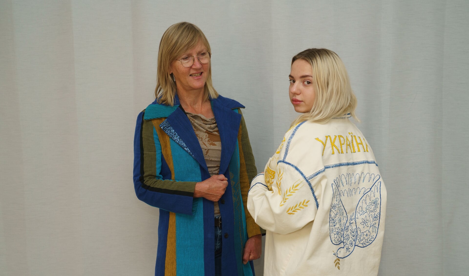 De Oekraïense Milena draagt met trots het jasje dat geborduurd is door de vluchtelingvrouwen van About a Jacket. Links Tineke van Lente, bij wie Milena en haar moeder inwonen.
