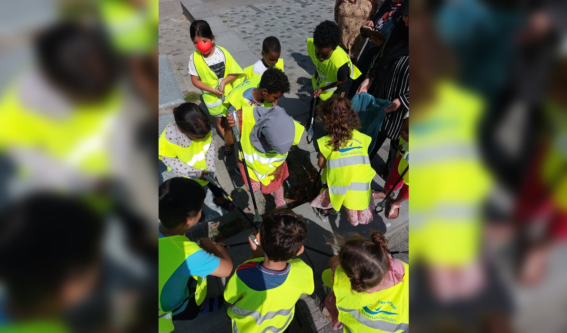 Kinderen en volwassenen van Wijkcentrum Dreesplein ruimen zwerfafval op.