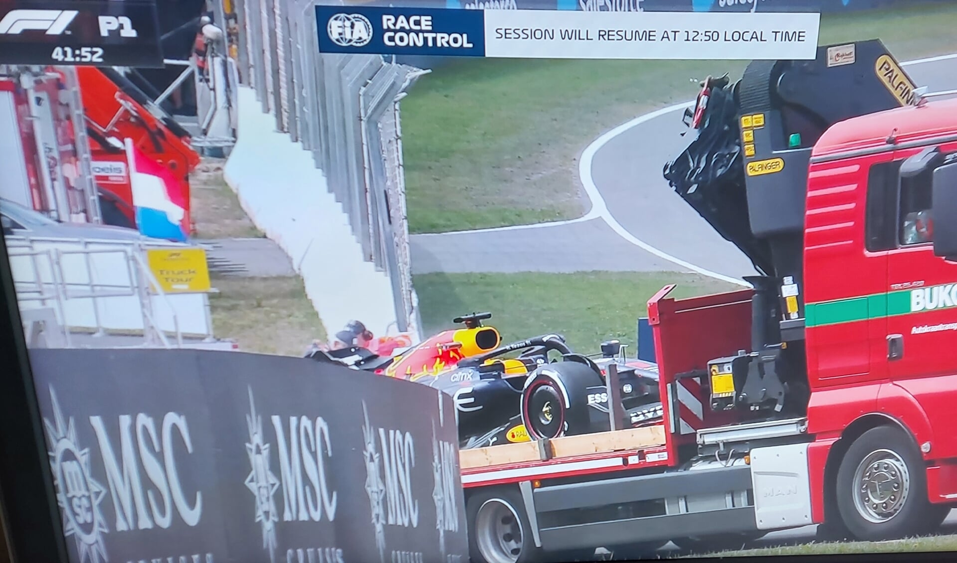 De bolide van Red Bull Racing wordt weggesleept.