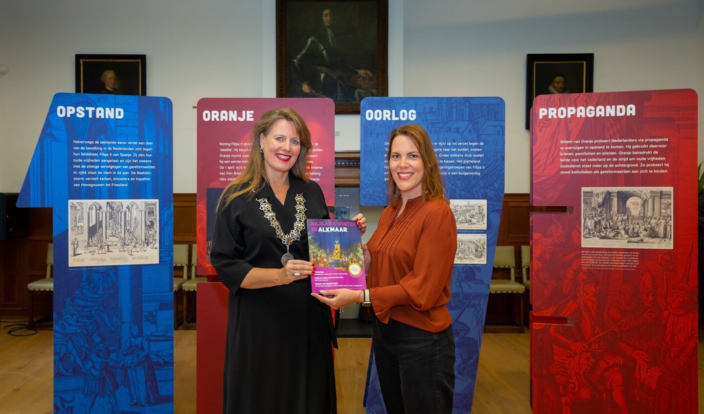 Hoofdredacteur Dorien Modderman reikt het eerste exemplaar van de Najaar & Wintereditie van het Alkmaar Prachtstad Magazine uit aan burgemeester Anja Schouten.