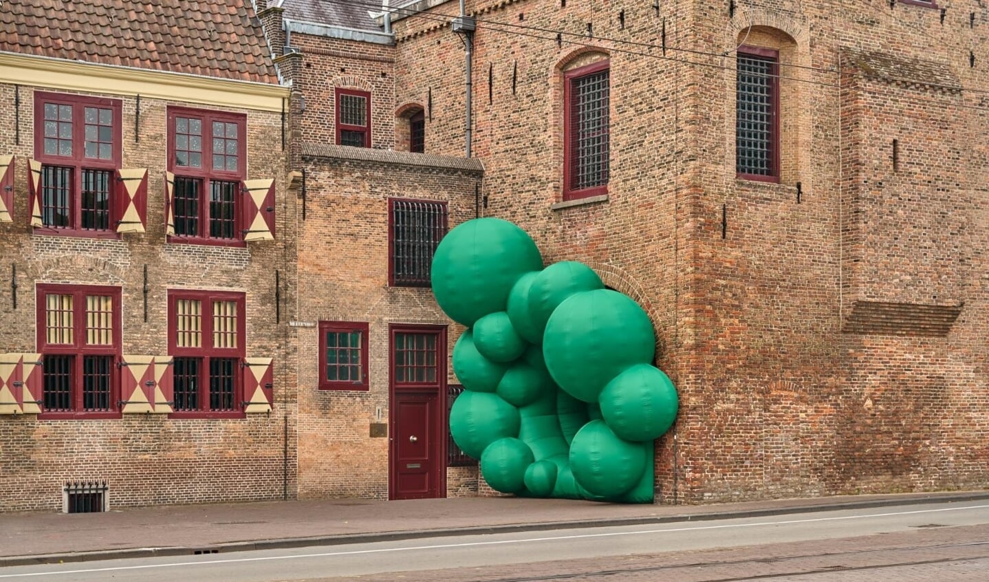 Steve Messam verandert met zijn ballonkunstwerk de hardheid van de Gevangenpoort in een vrolijk bubbelende omhelzing. 