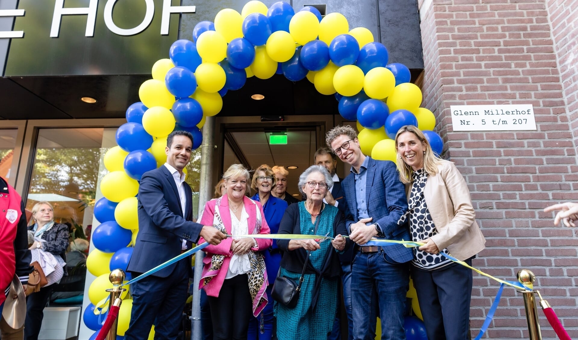 Bewoonster Ria van Es knipt het lint door, geflankeerd door stadsdeeldirecteur Mustapha el Boumeshouli, Nancy Krul van de Stichting Verzilveren), wethouder Martijn Balster en Marieke Stam van Staedion.