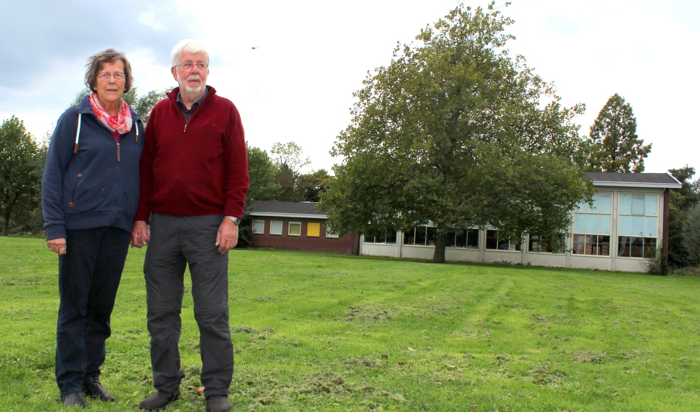 Ria en Piet Beukenkamp voor de oude gymzaal waarin SOEB nu nog gehuisvest is. De hulporganisatie moet het pand verlaten vanwege nieuwbouw, maar kan geen andere plek vinden.