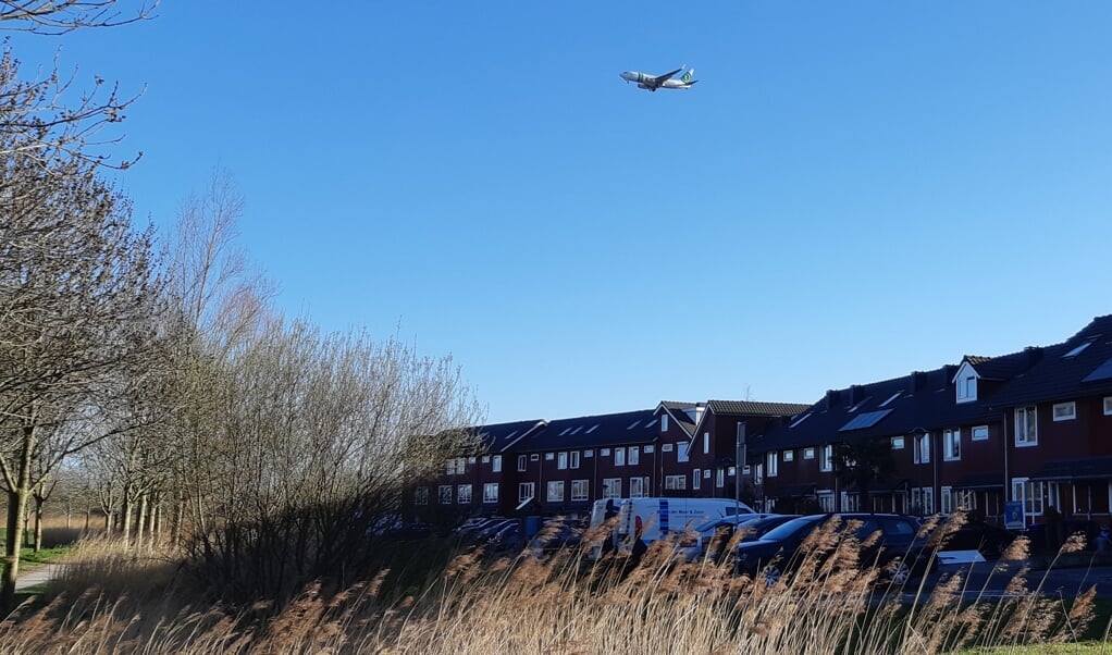 Een vliegtuig scheert laag over de woningen van Schiedam-Noord.