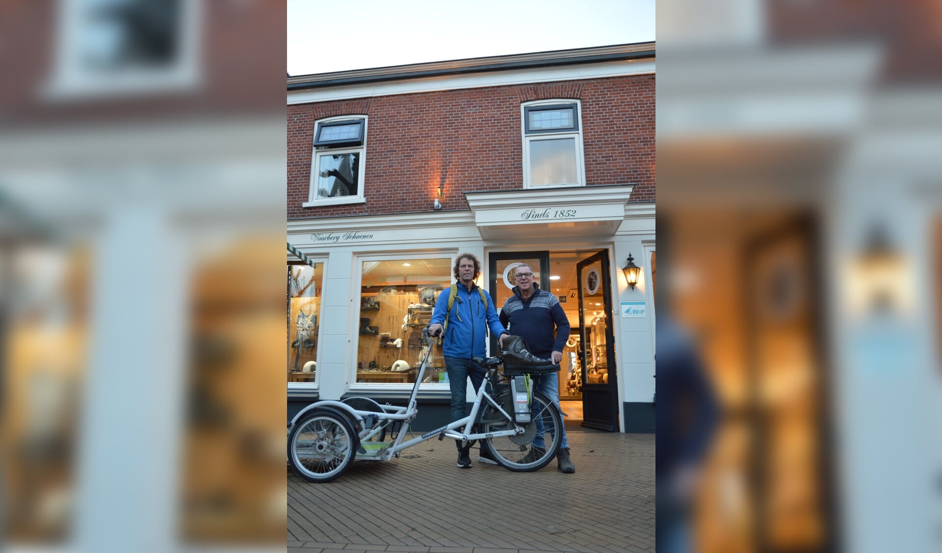 Cees Voorberg (links) van Voorberg Schoenen en Hans Prins van Stichting Avavieren bij een goede investering. Deze fiets van Avavieren biedt mensen in een rolstoel de gelegenheid om, samen met een begeleider, te genieten van het mooie Westland.