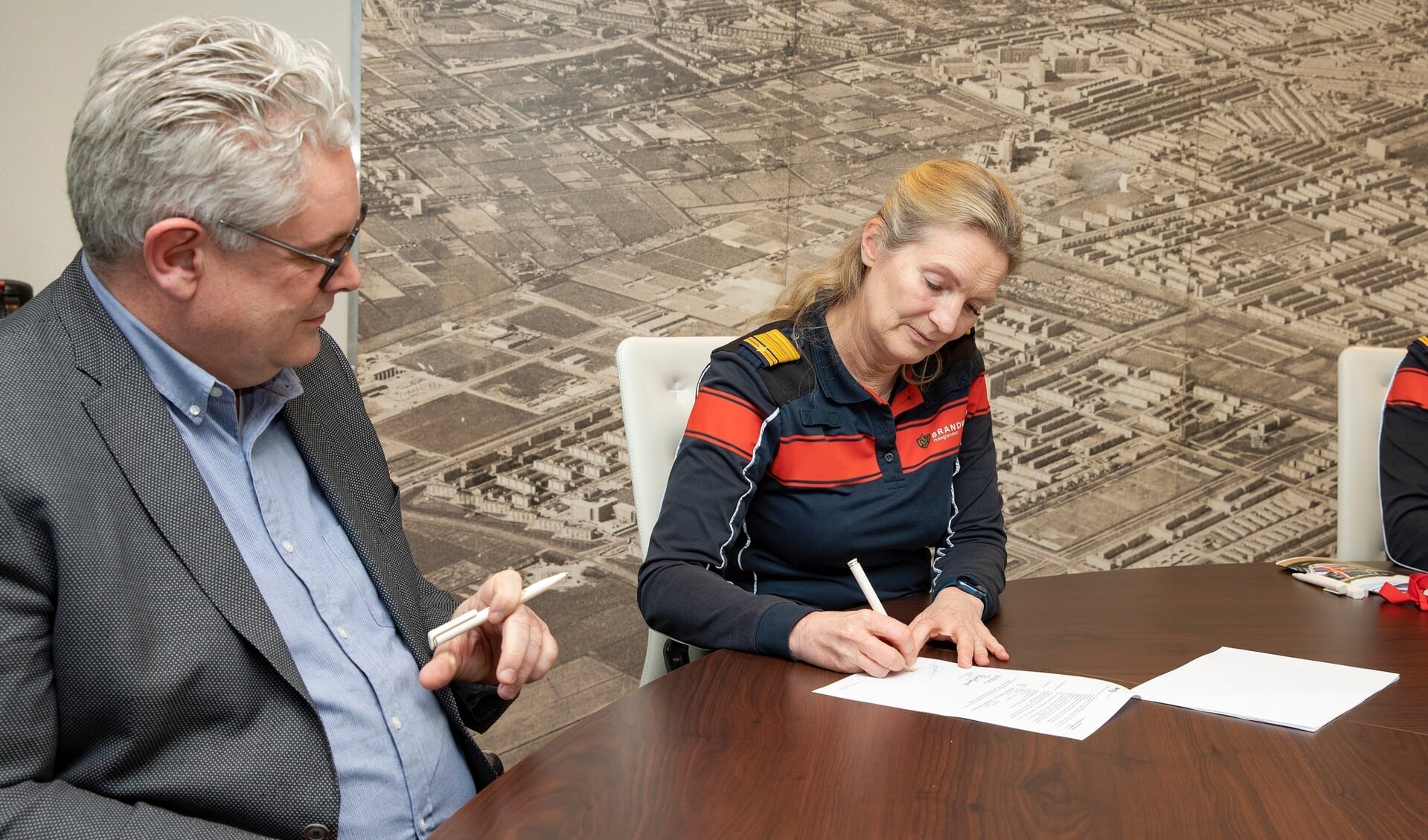 Esther Lieben, commandant Brandweer Haaglanden, ondertekent het contract met de leverancier van de voertuigen.