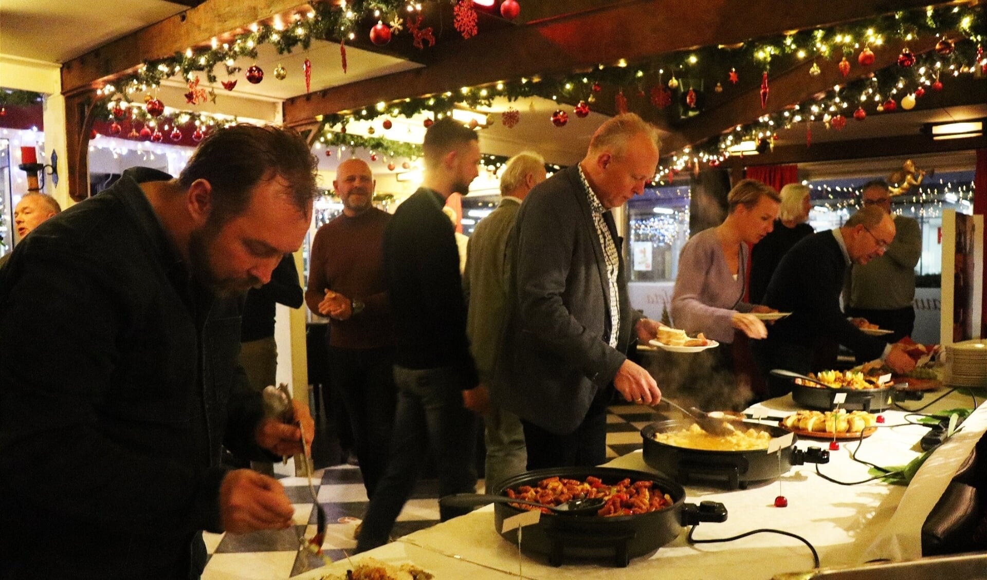 De ondernemers scheppen enthousiast op bij het lopend buffet in La Caleta. In het midden staat Wim Veldhoen.